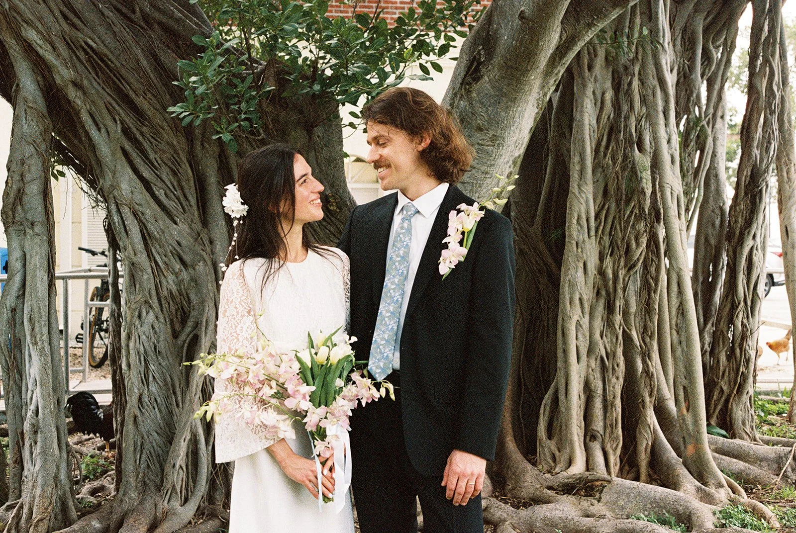 35mm film photo of a couple posing in front of a tree outside of Monroe County Courthouse in Key West, FL