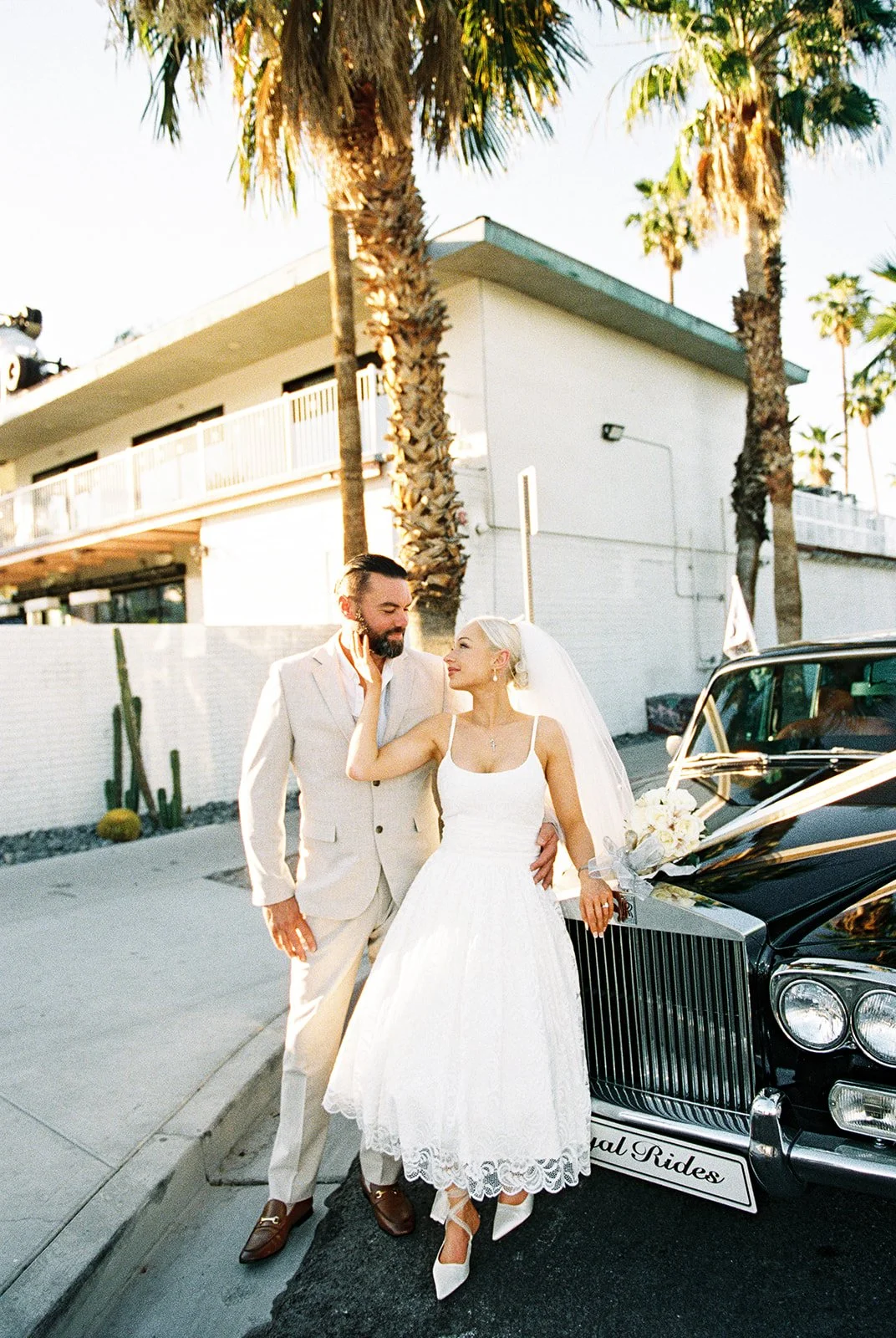 Bride and groom posing in front of a classic car from Royal Rides in Las Vegas.