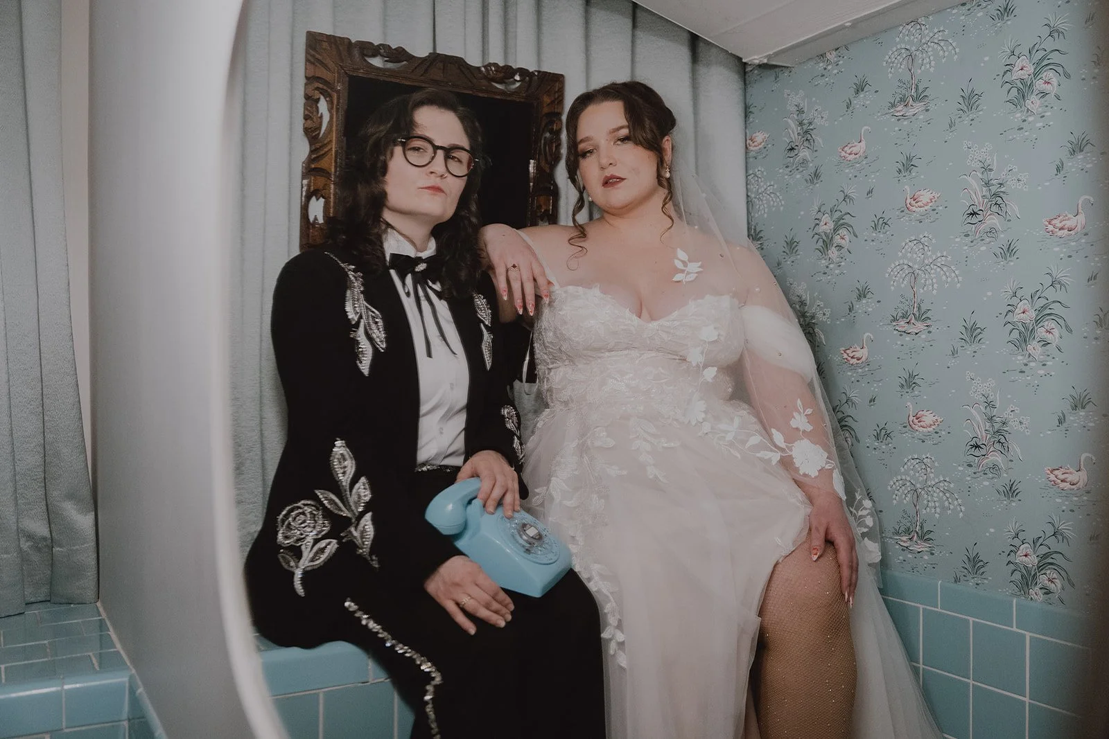 Couple taking editorial wedding portraits in the blue tiled bathroom at Sure Thing Chapel.