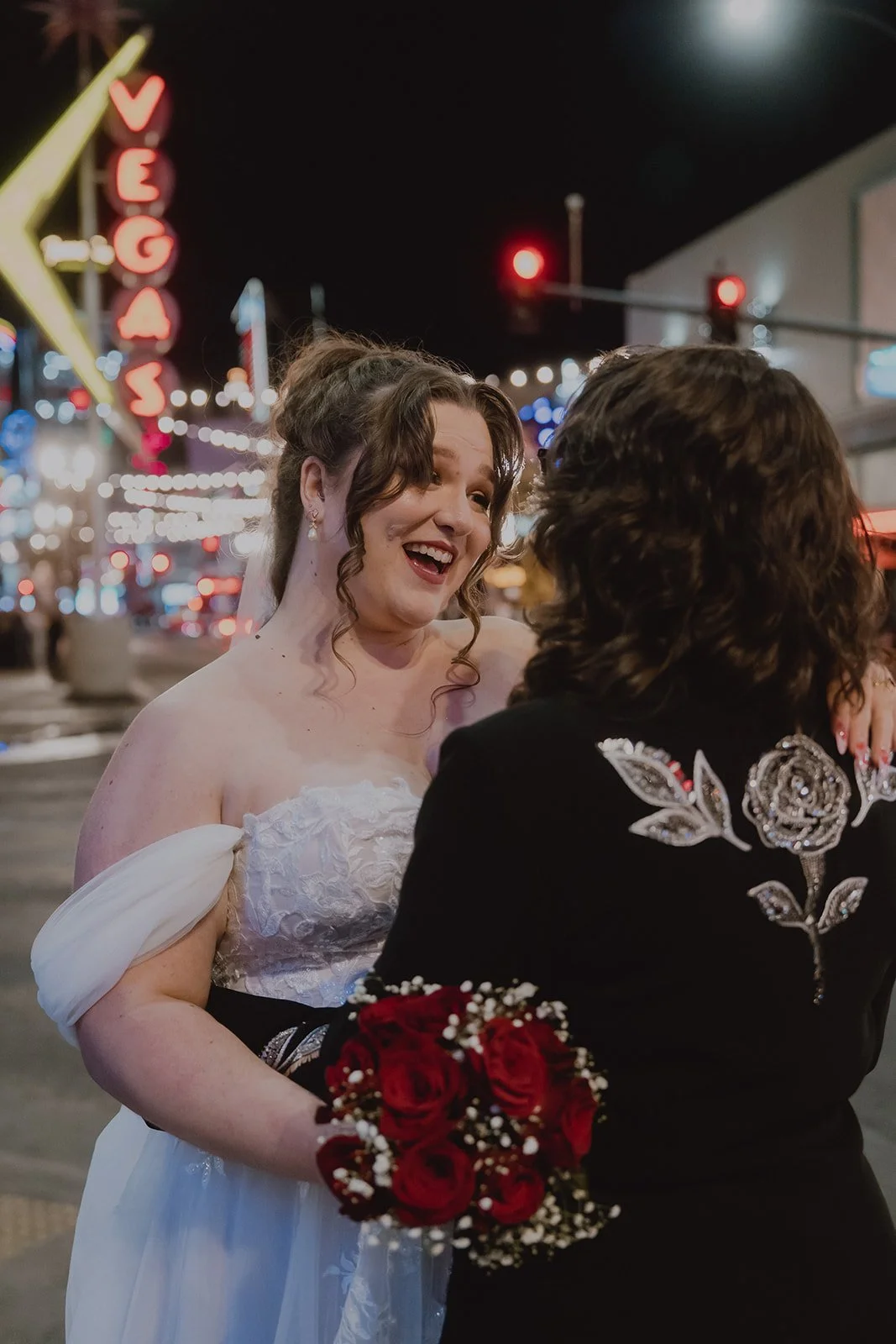 Couple laughing together during nighttime Fremont Street wedding portraits.
