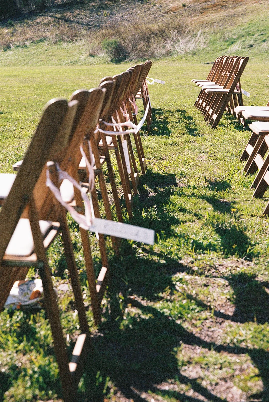 Film photo of wooden wedding ceremony chairs.