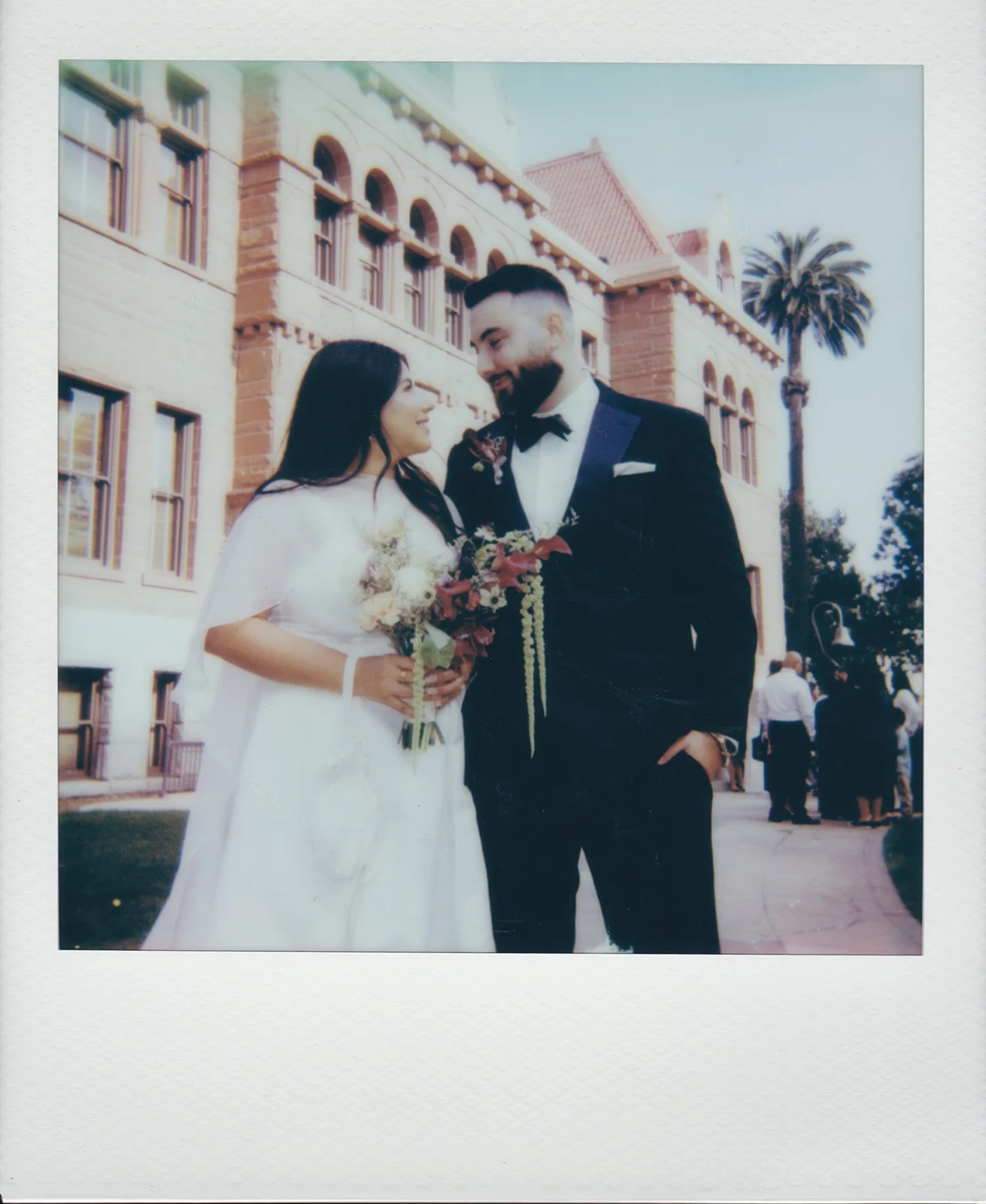 Polaroid wedding photo of a couple posing outside of the Old Orange County Courthouse.