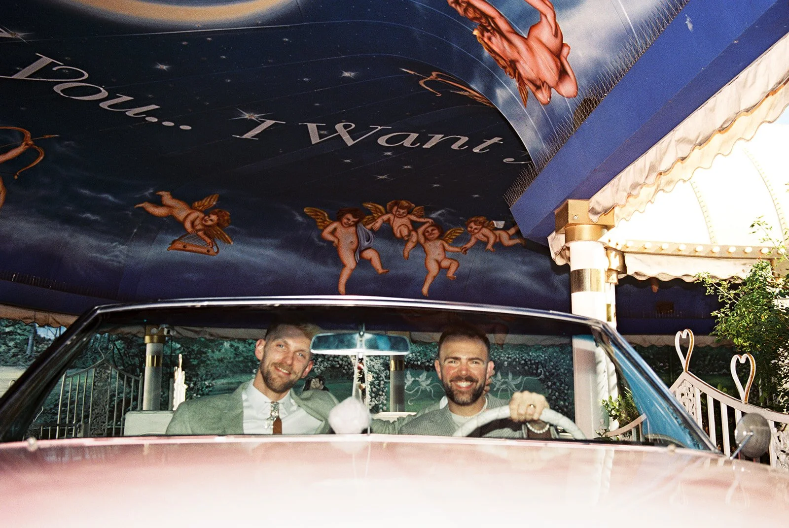 Couple sitting in the Pink Cadillac at a Little White Wedding Chapel on 35mm film.