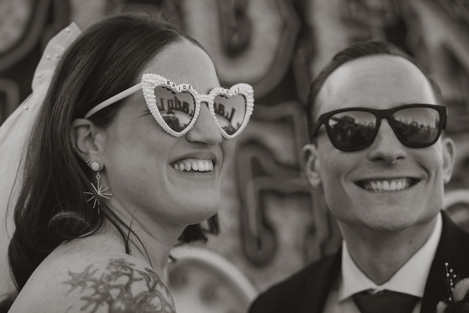 Close up black and white photo of a bride and groom wearing sunglasses during their Neon Museum Las Vegas wedding.