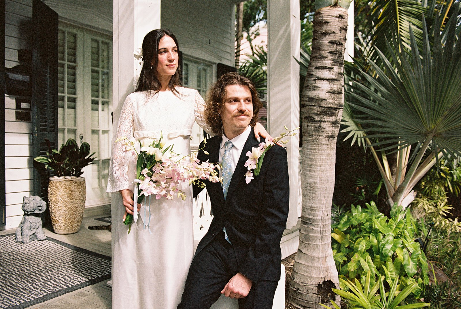 Bride and groom standing together on the steps of Old Town Manor in Key West, FL.