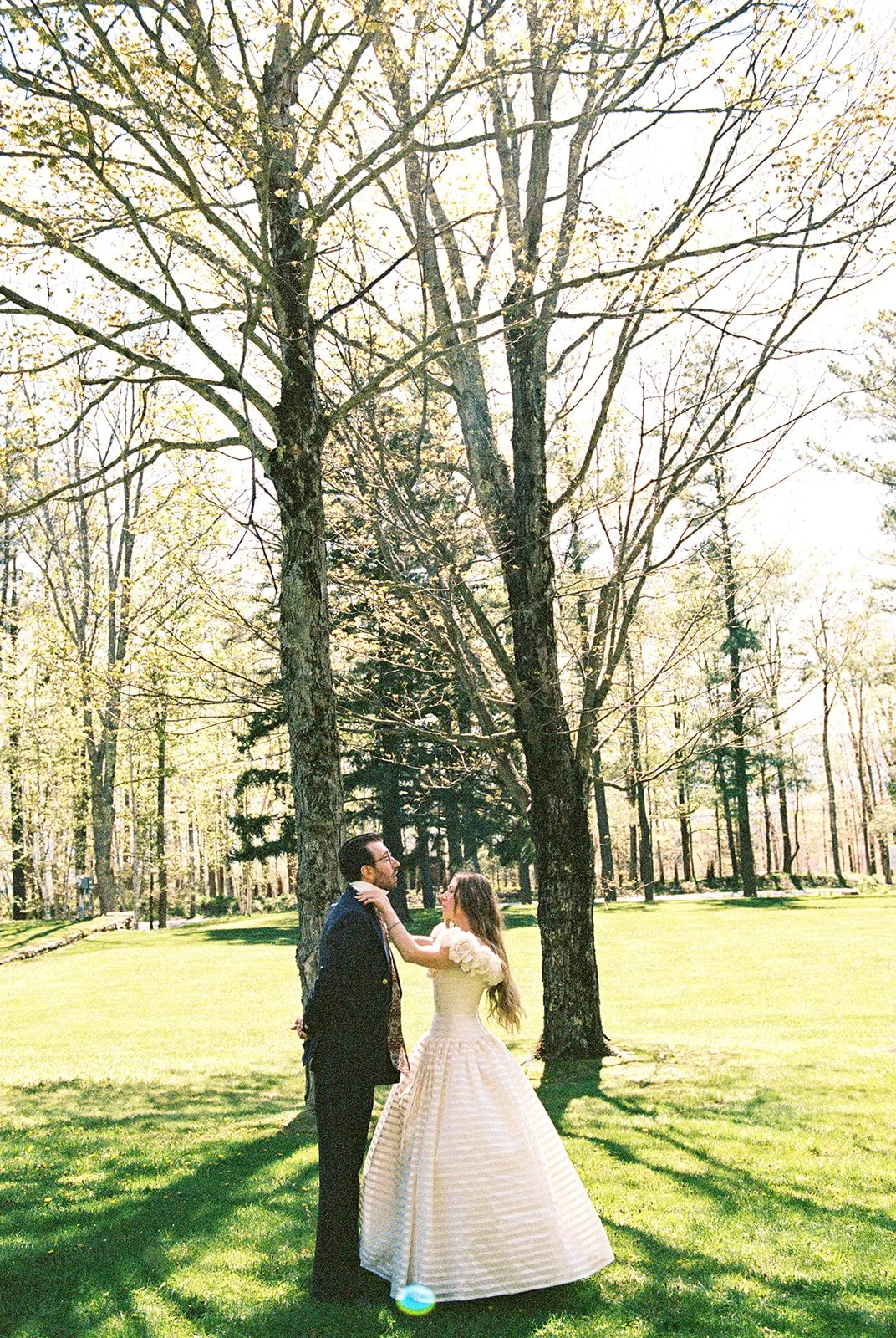 Bride adjusting the grooms tie during their first look outdoors.