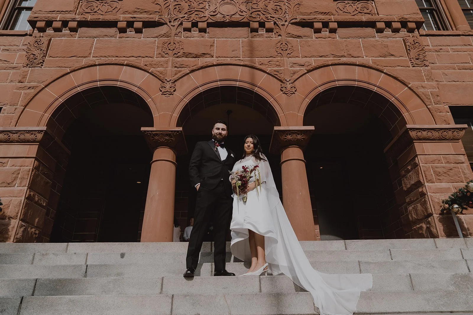 Couple posing outside of Old Orange County Courthouse.