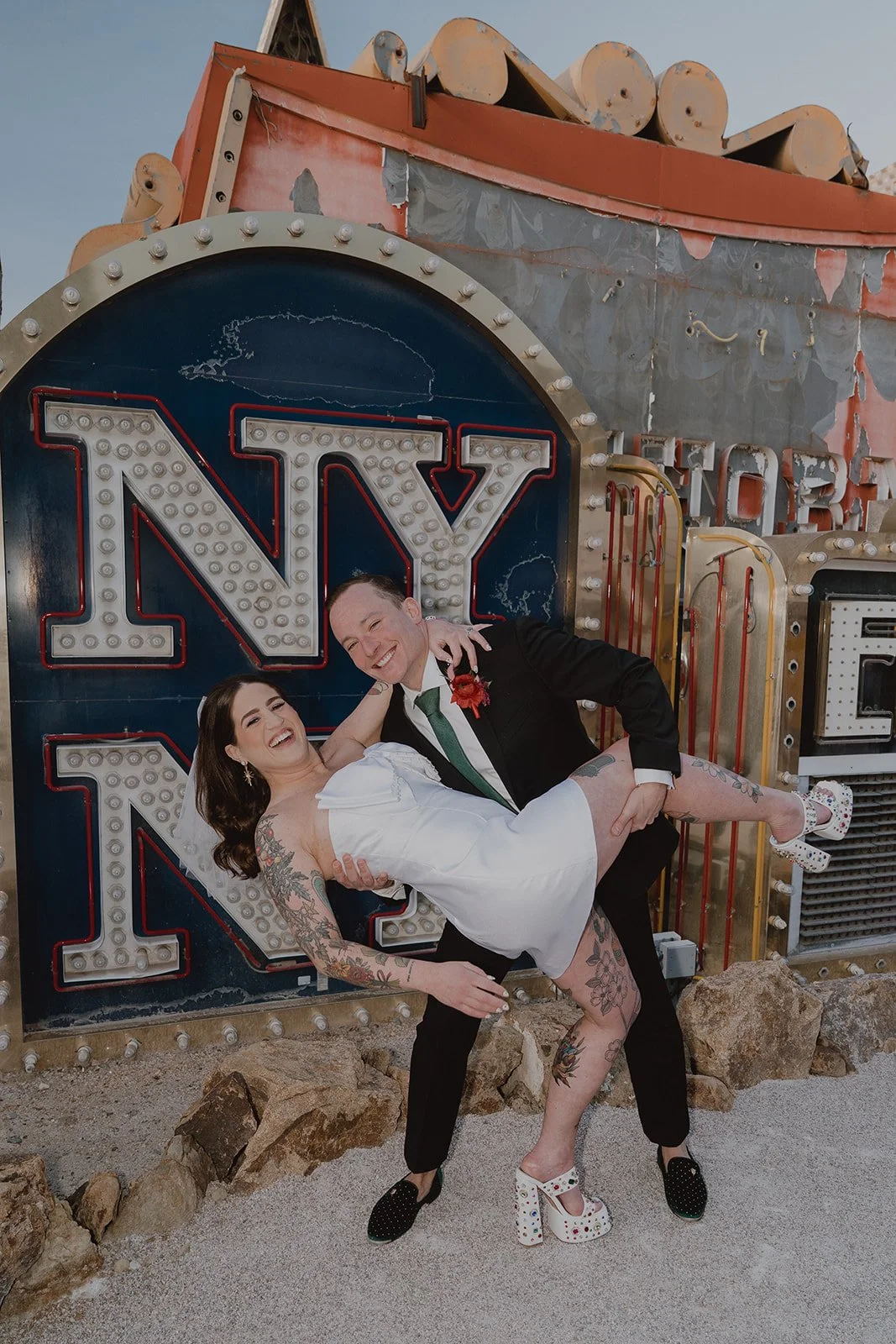 Bride and groom posing in front of the signs at The Neon Museum.