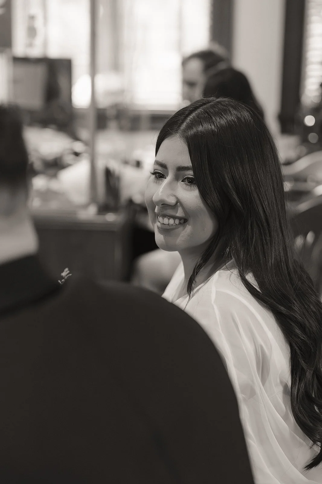 Black and white photo of a bride smiling at the groom at the Old Orange County Courthouse in Santa Ana, California.