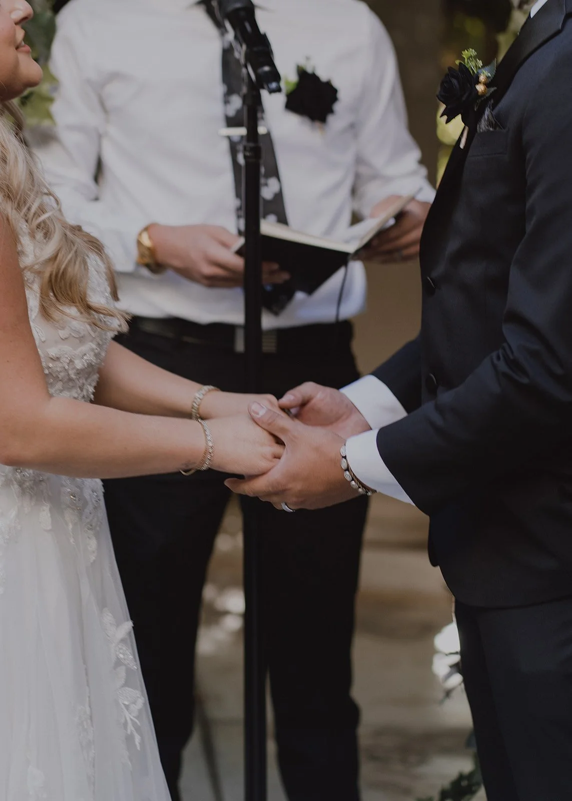 Close up of a bride and groom holding hands during their wedding ceremony