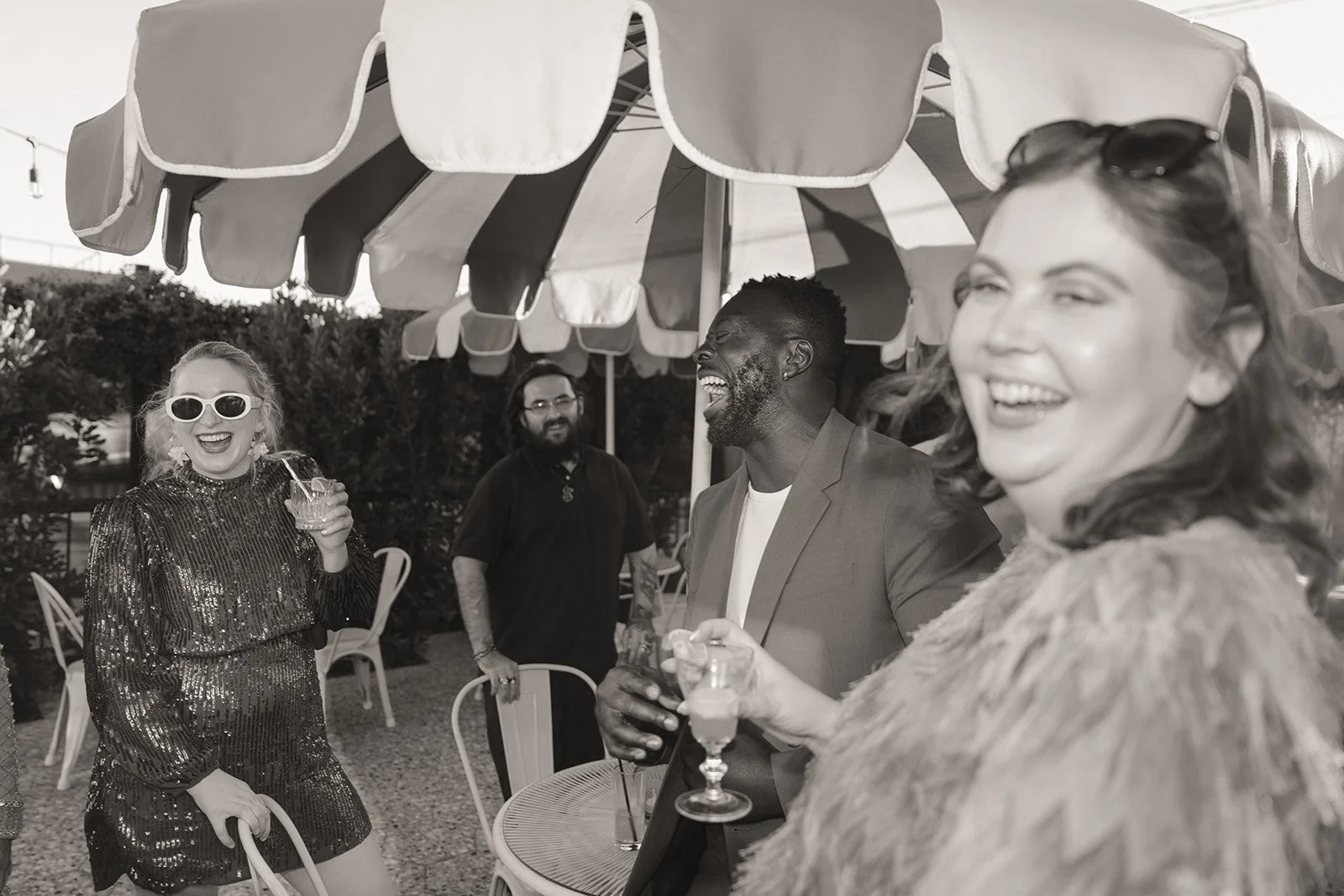 Guests laughing and holding drinks during an outdoor Velveteen Rabbit Las Vegas micro wedding reception.
