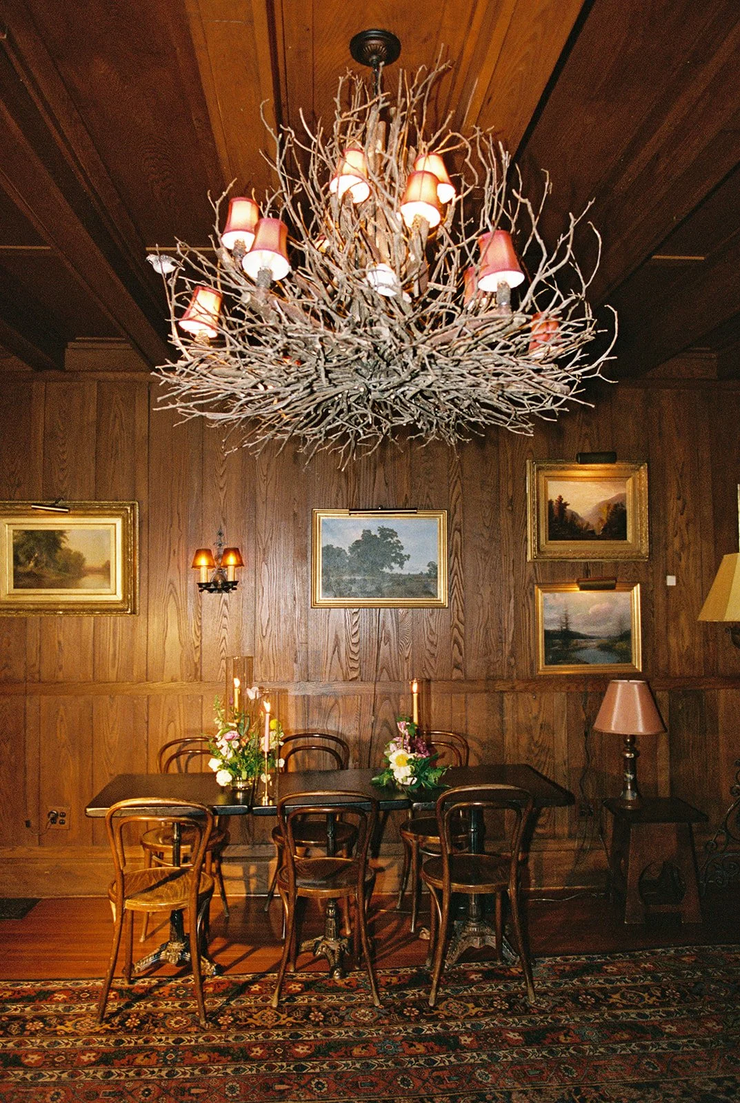 Film photo of a rustic branch chandelier hanging above a candlelit reception table at Deer Mountain Inn.