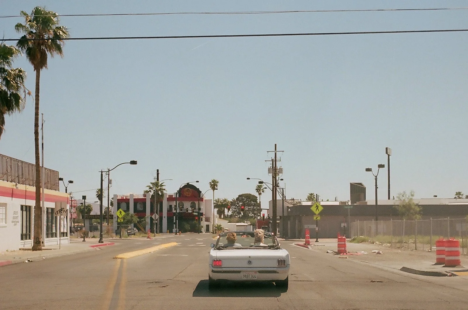 Couple driving down the road in  classic car during their vintage Vegas wedding photos.