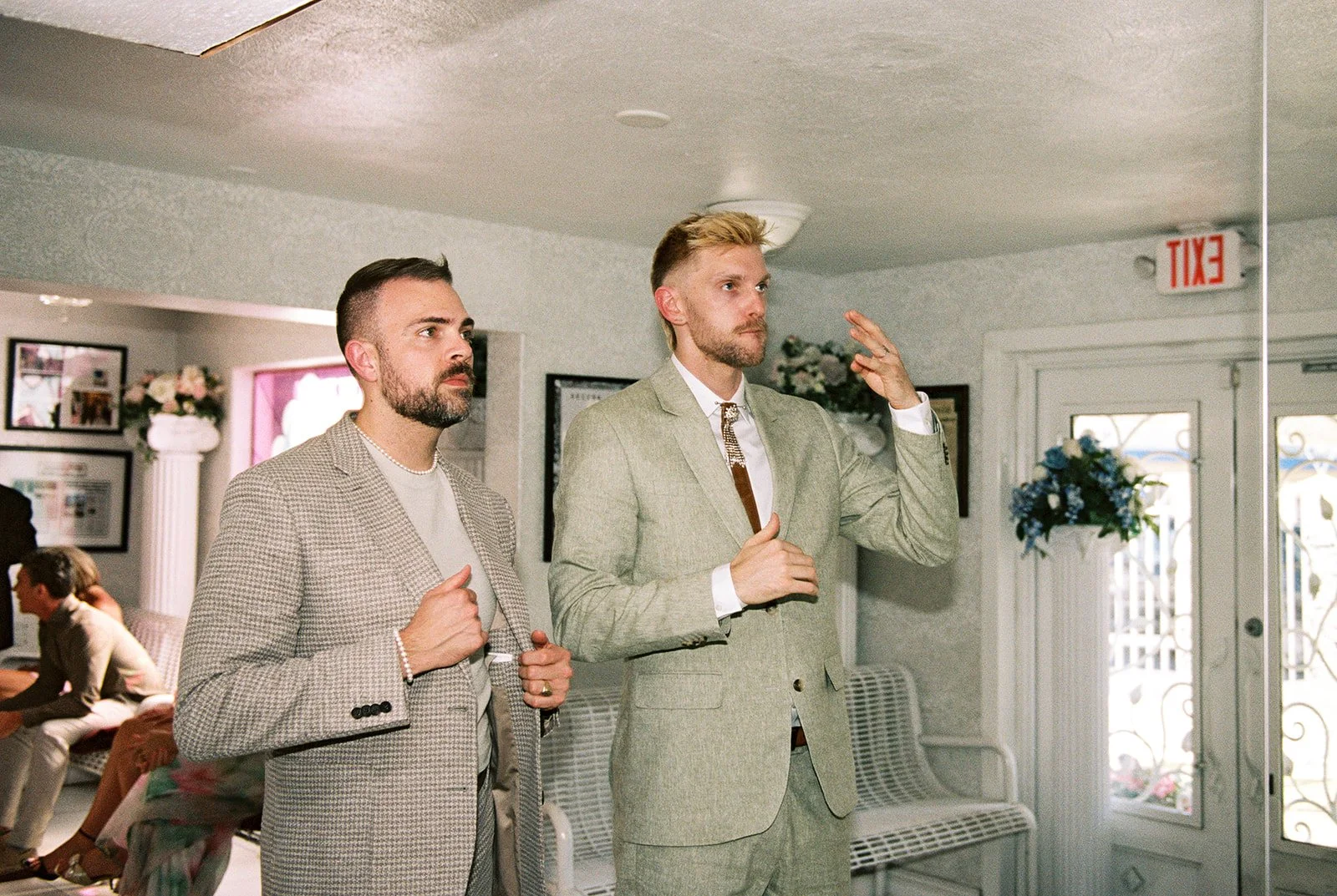 Couple making sure they're ready in the mirror as they wait in the waiting room for their time.