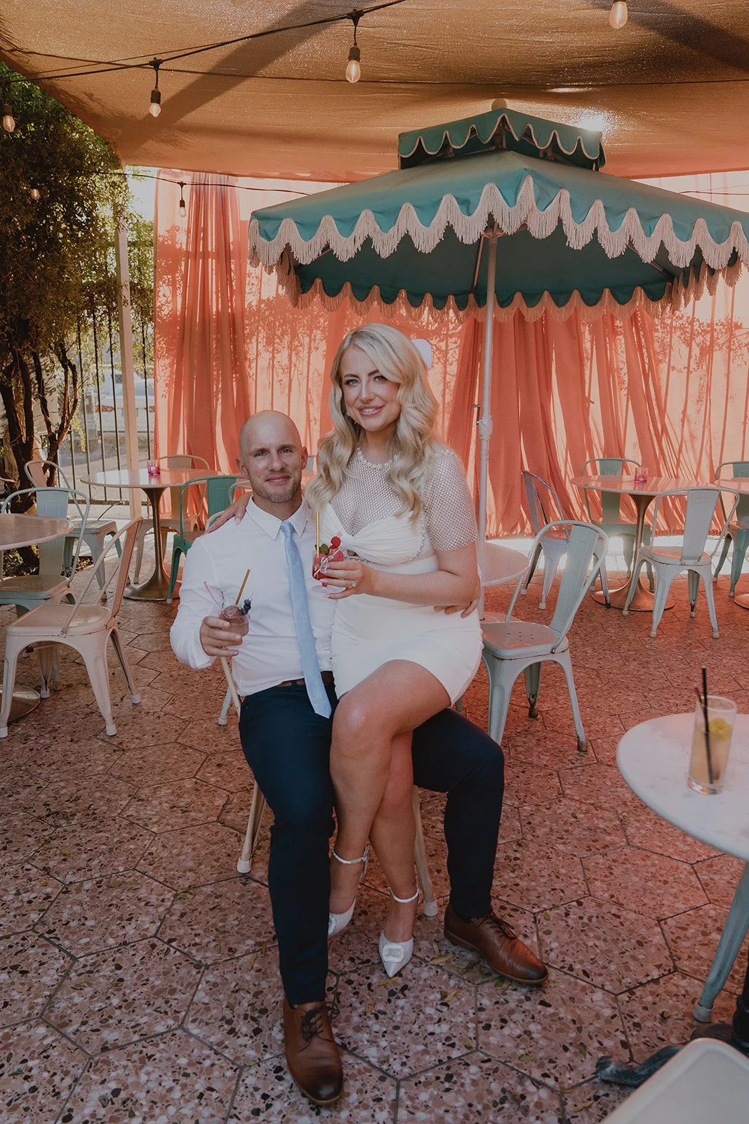 Bride and groom seated together under the shaded Pink Palace Patio at Velveteen Rabbit during their Las Vegas micro wedding reception.