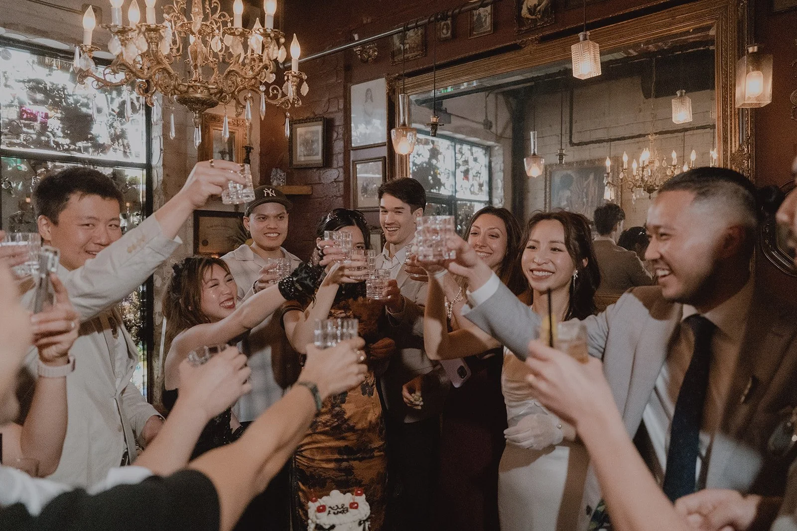 Bride, groom, and their guests toasting with drinks inside of The Laundry Room.
