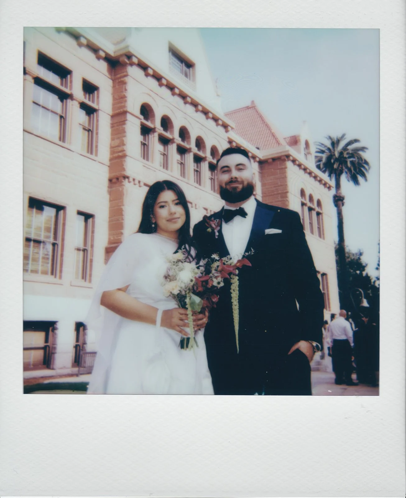Polaroid wedding photo of a couple posing outside of Old Orange County Courthouse in Santa Ana, California.