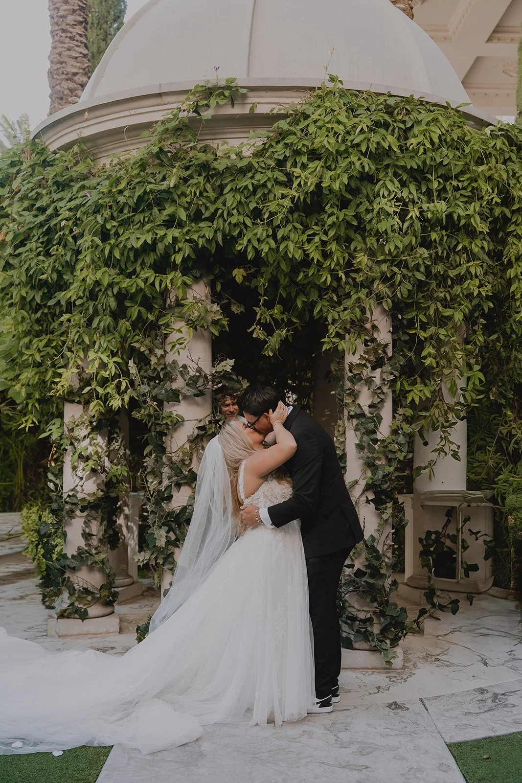 Bride and groom kissing during their Caesars Palace Venus Garden wedding ceremony