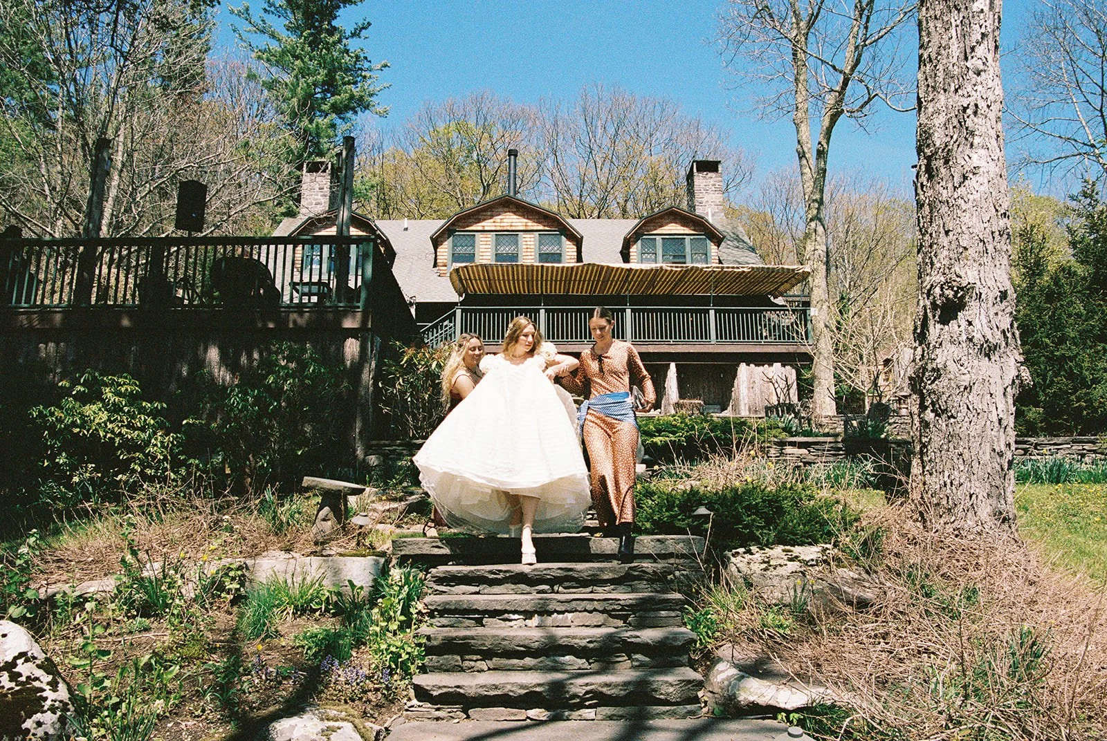 Bride walking down the stairs outside of Deer Mountain Inn for her first look with the groom.
