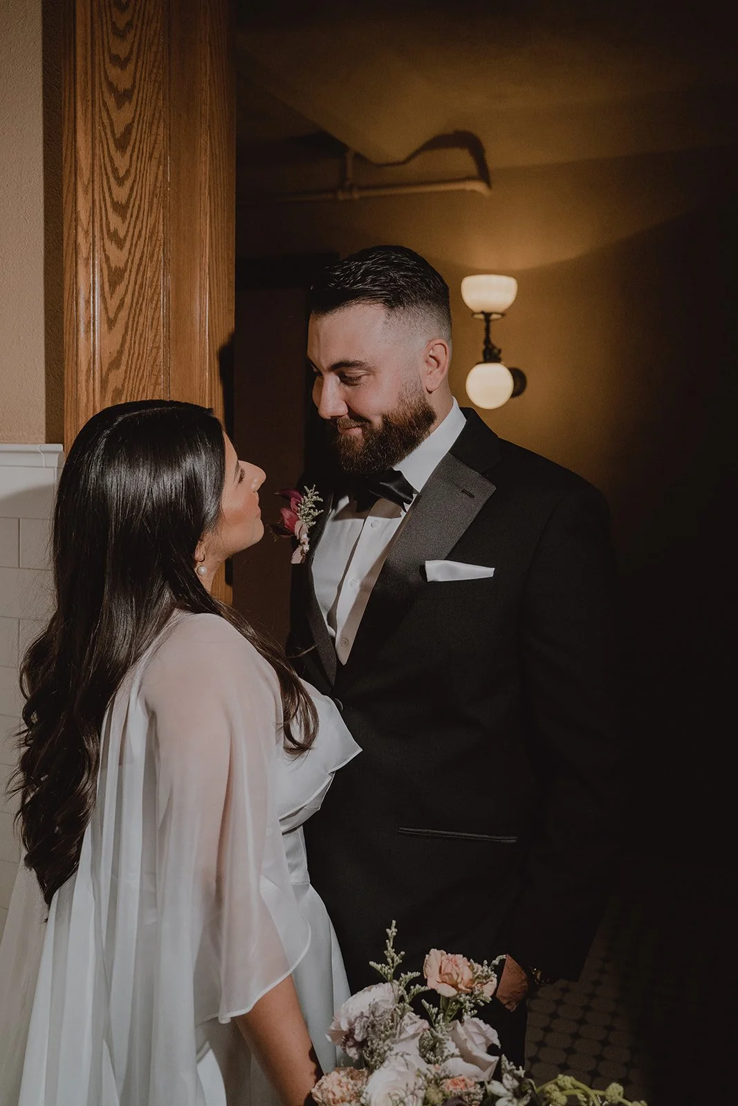 Couple smiling at each other for their Old Orange County Courthouse wedding portraits.