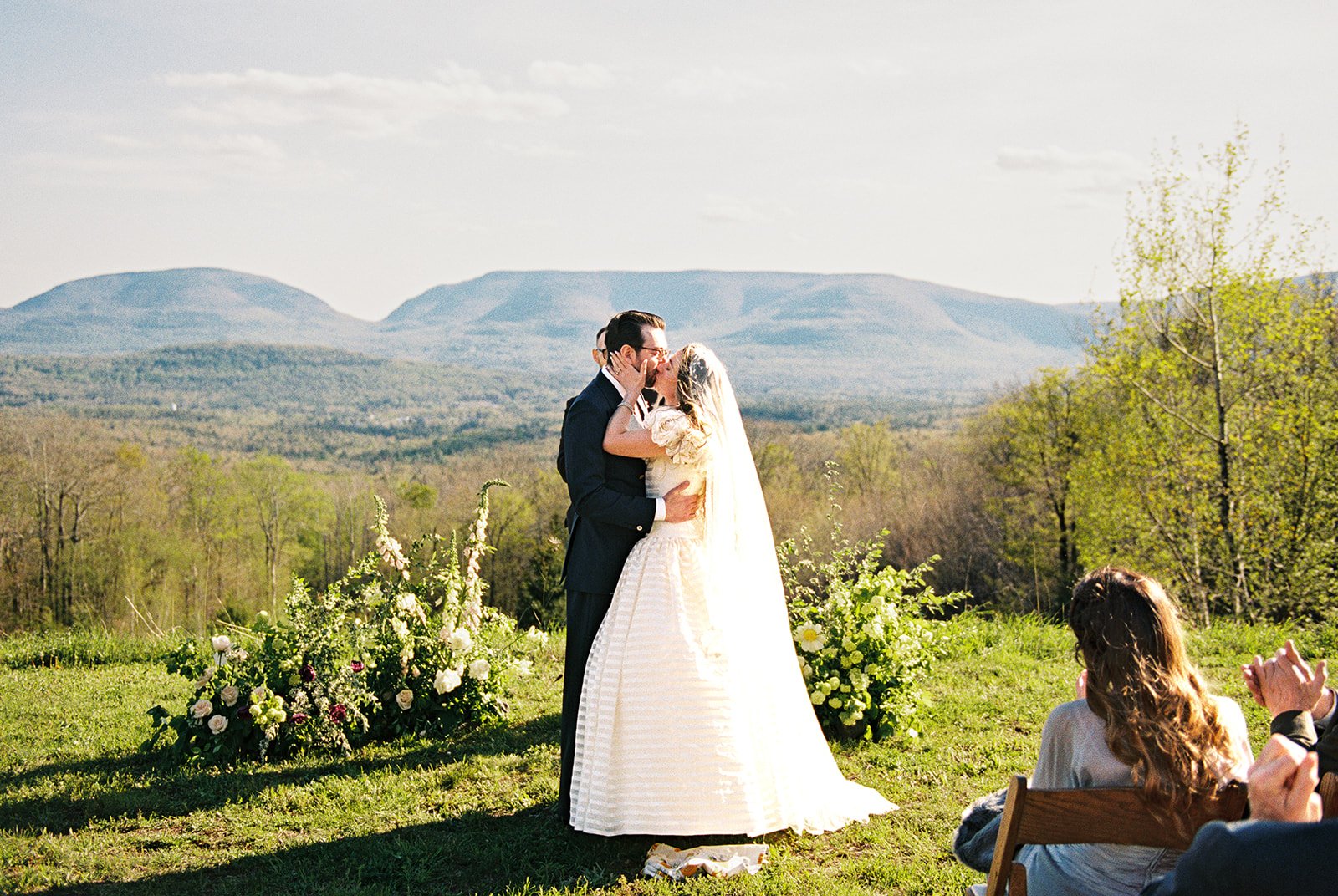 Bride and groom kissing during their Northern Catskill Mountain wedding on film.