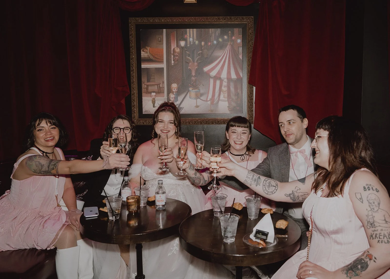 Couple and wedding party toasting with champagne during a small reception at Cheapshot.