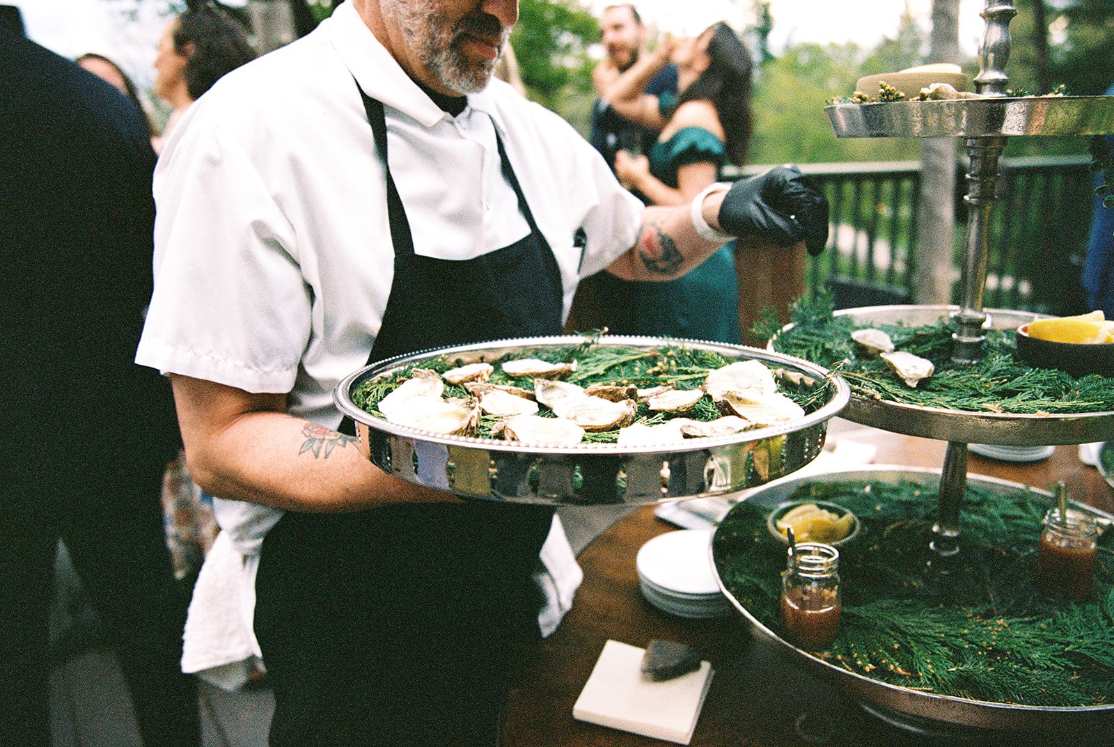 Film photo of a server presenting oysters during cocktail hour at Deer Mountain Inn.