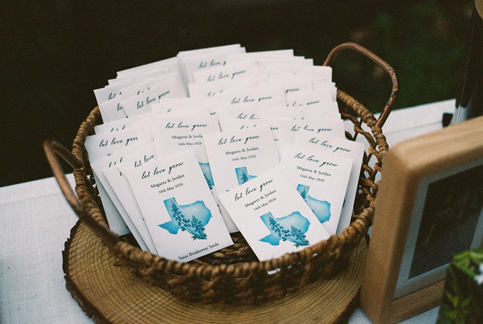Film photo of personalized “Let Love Grow” wildflower seed favors displayed in a woven basket at Deer Mountain Inn.