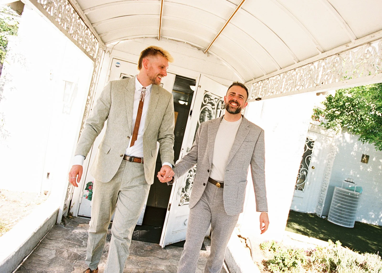 Couple walking outside of The Little White Wedding Chapel smiling as a newly married couple.