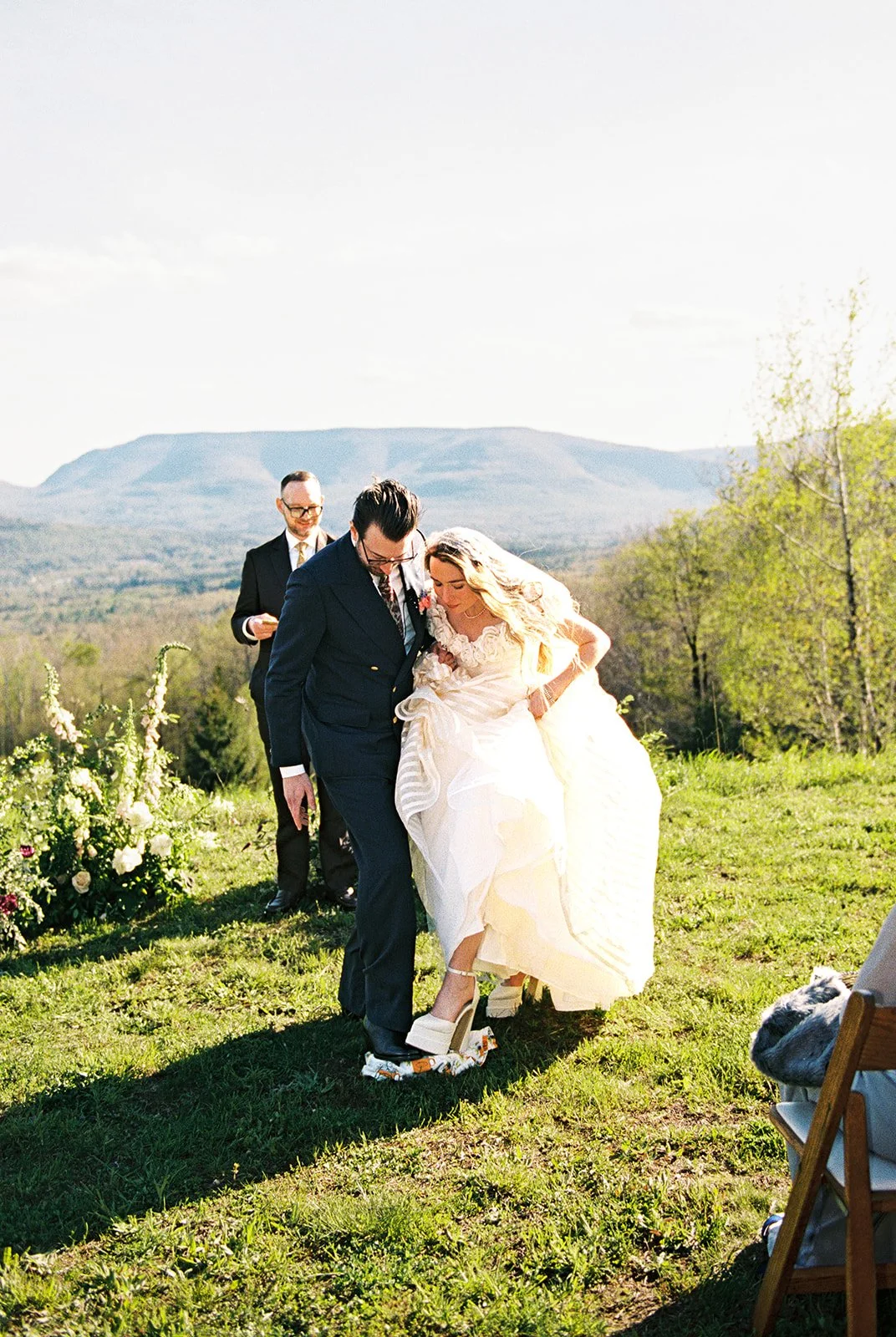 Bride and groom stepping on something before their kiss.