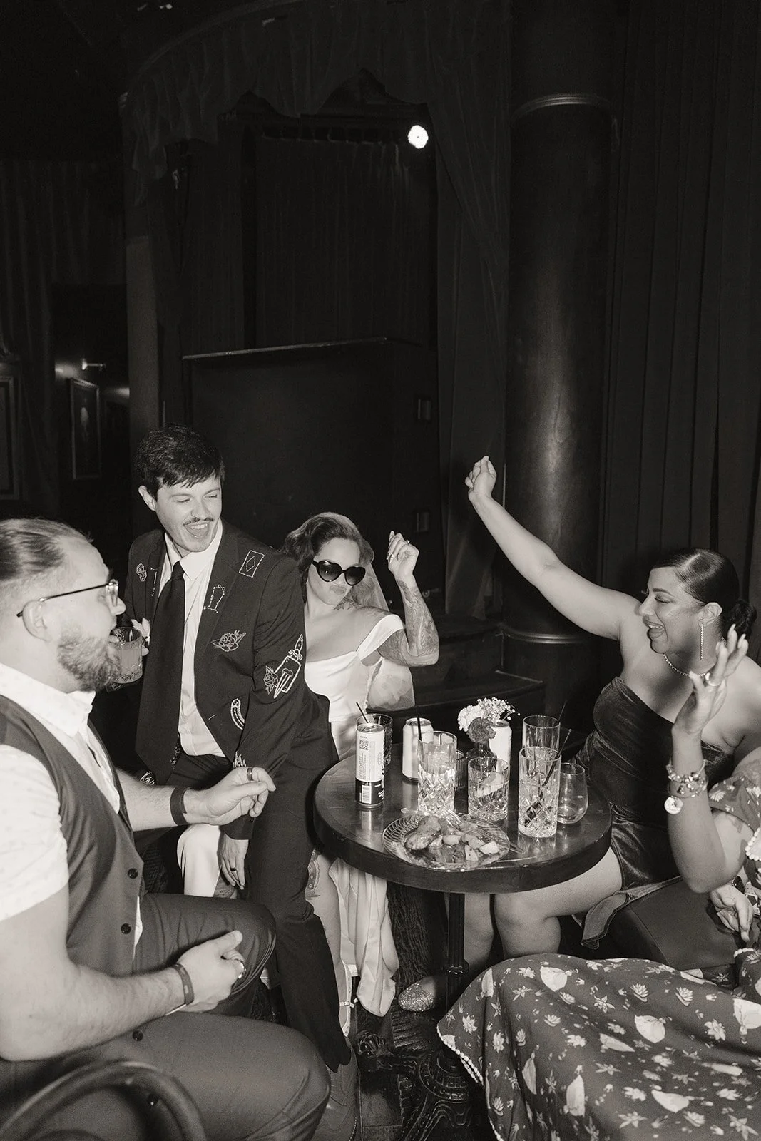 Black and white photo of a bride and groom laughing with their friends at Cheapshot in Las Vegas.