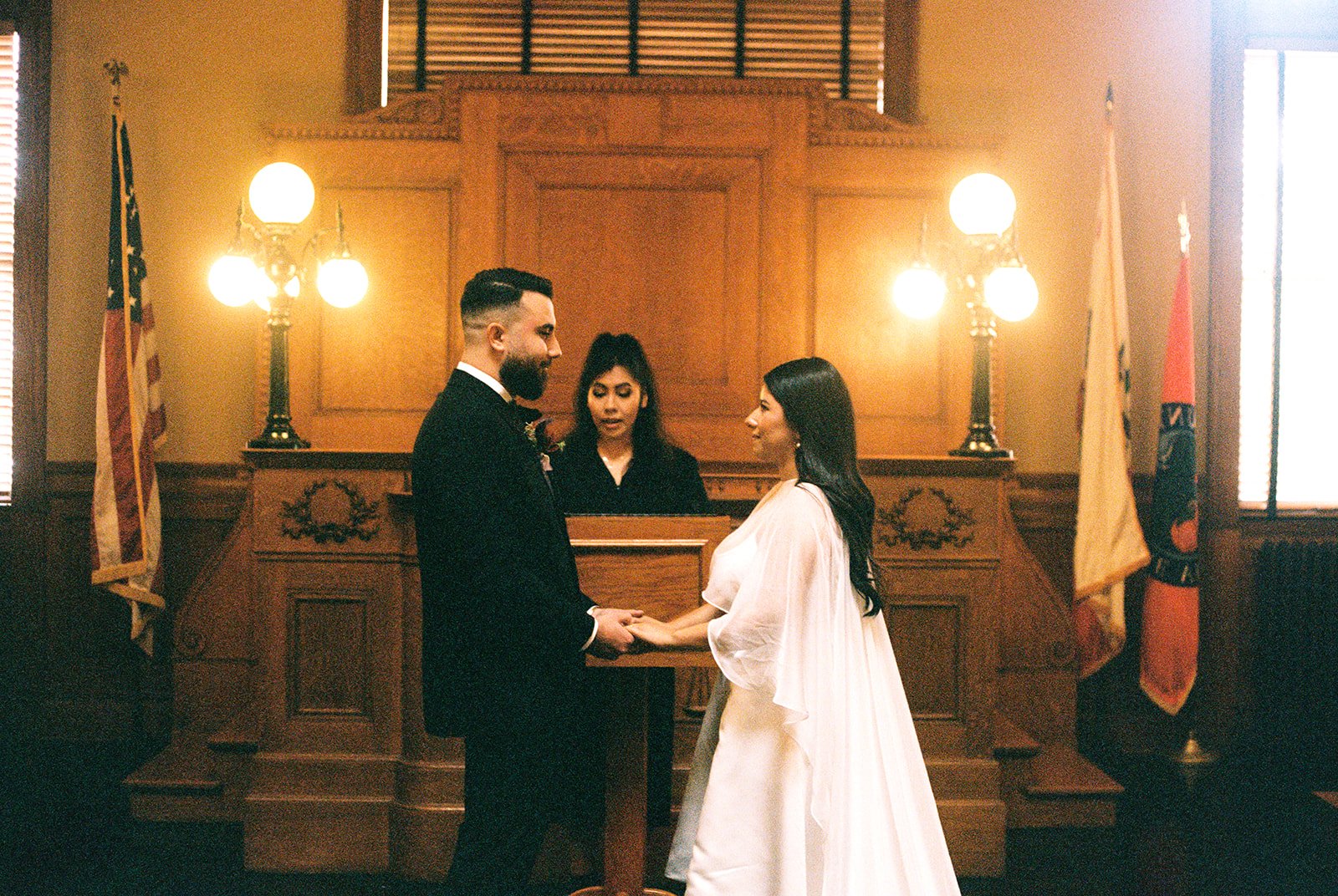 35mm film photo of a couple holding hands at the altar.