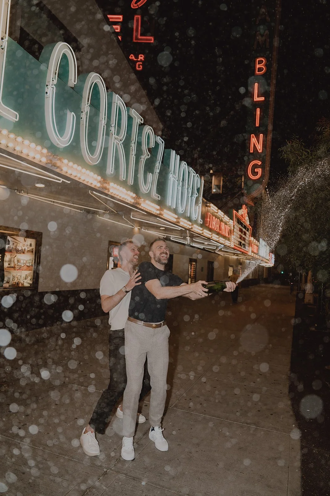 Couple popping champagne during their Las Vegas Fremont Street elopement.