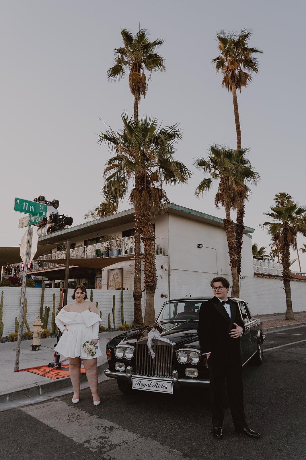 Bride and groom posing in front of a classic car from Royal Rides in Las Vegas.