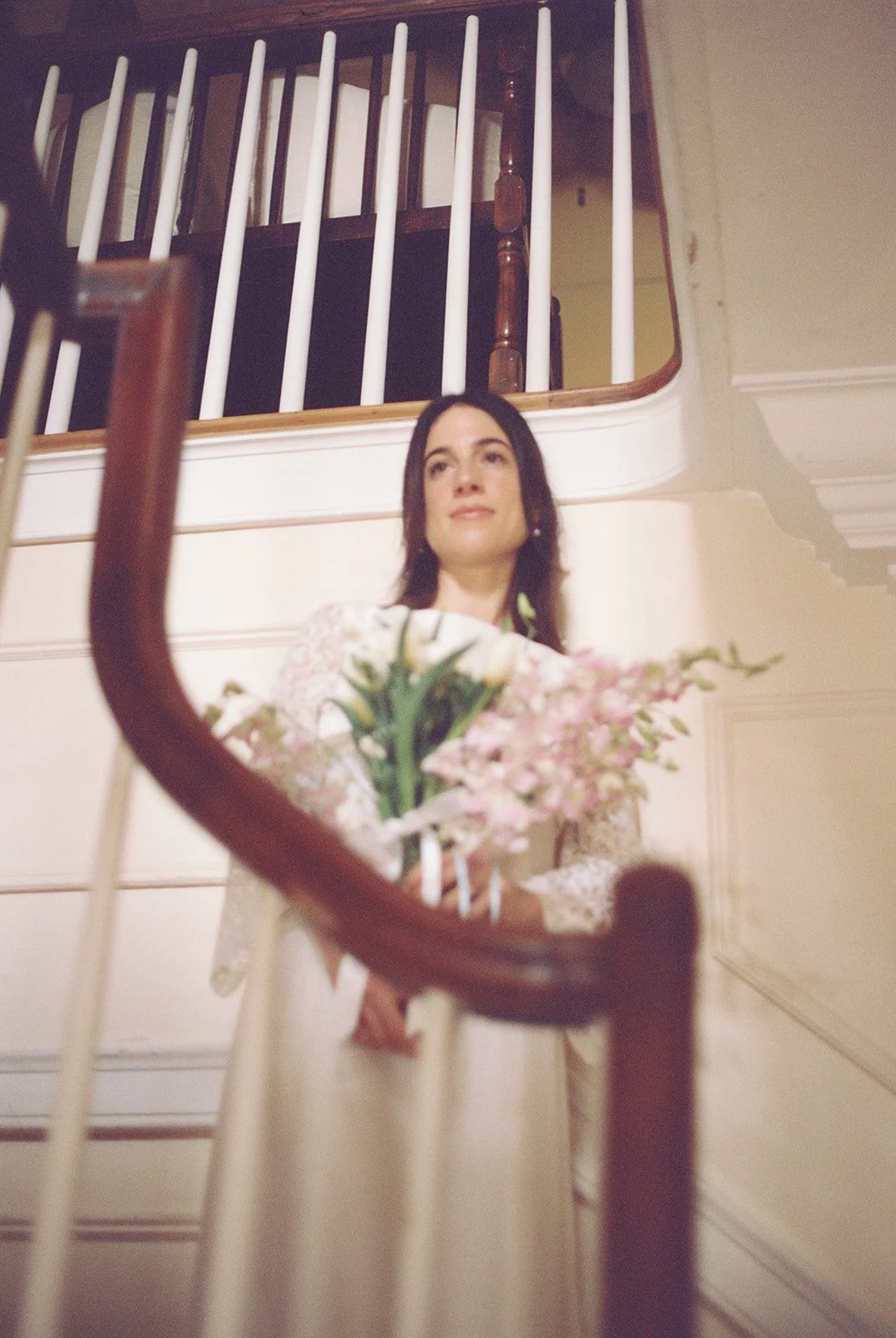 Bride smiling on the curved staircase inside historic Old Town Manor built in 1886 in Key West, Florida.