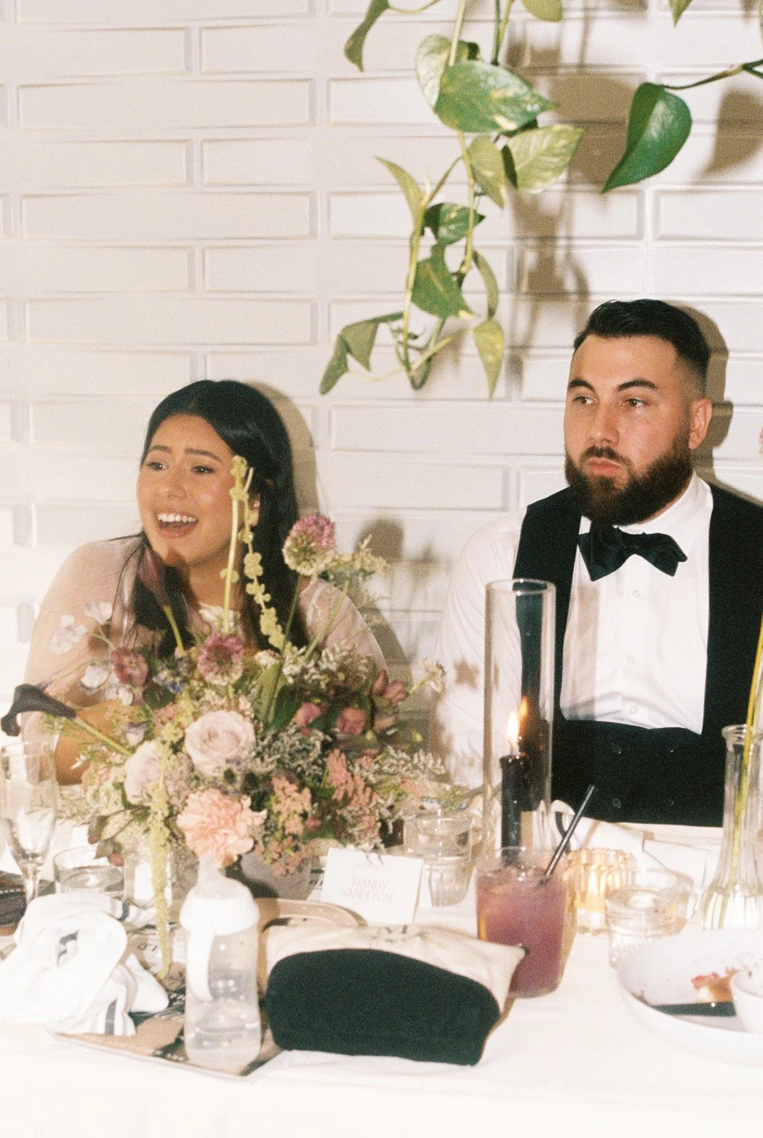 35mm film photo of a bride and groom laughing during their Orange County micro wedding reception brunch at Benchmark Restaurant.