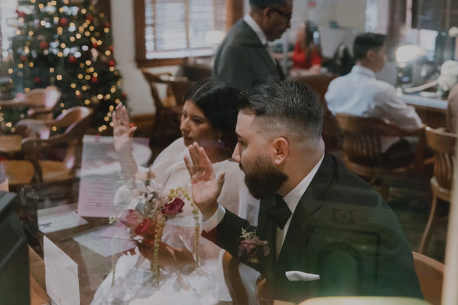 Bride and groom holding up their right hands at the Old Orange County Courthouse.