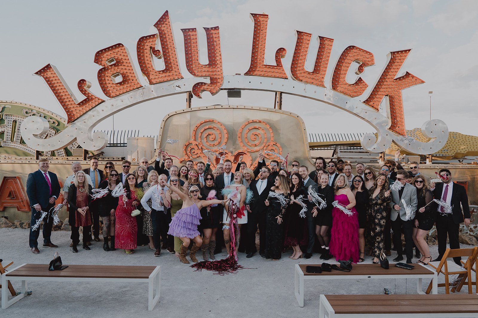 Bride and groom posing with their wedding guests during a big group shot at The Neon Museum in Las Vegas.
