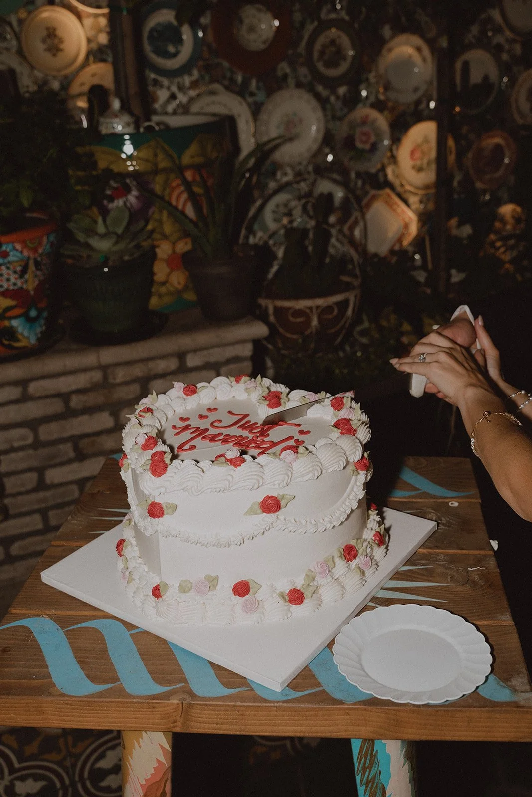 Couple cutting into their heart shaped wedding cake.