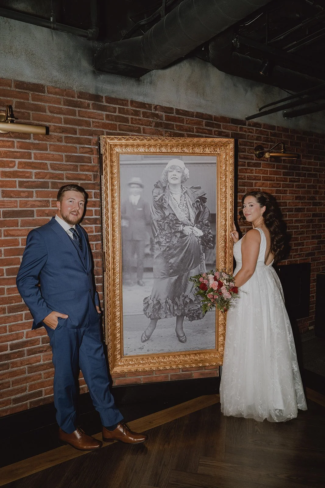 Bride and groom posing with vintage artwork at The Mob Museum in Las Vegas.