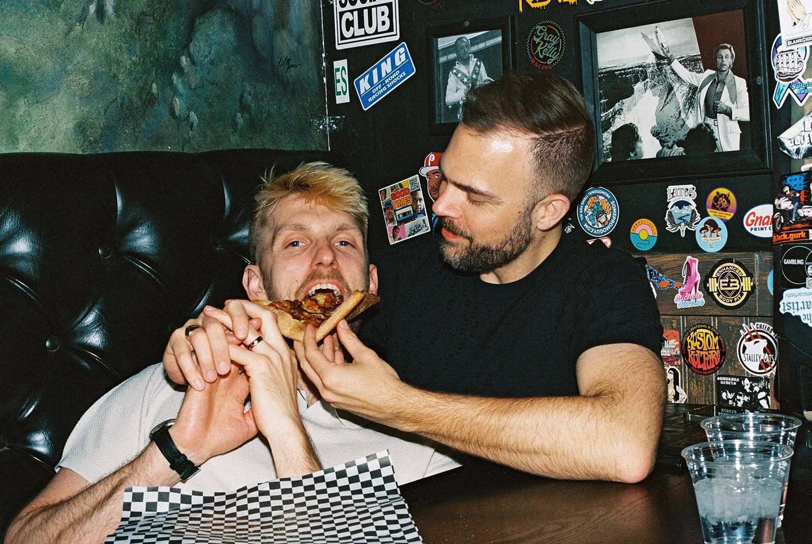 Man feeding his husband a slice of pizza from Evel Pie in Las Vegas on 35mm film.