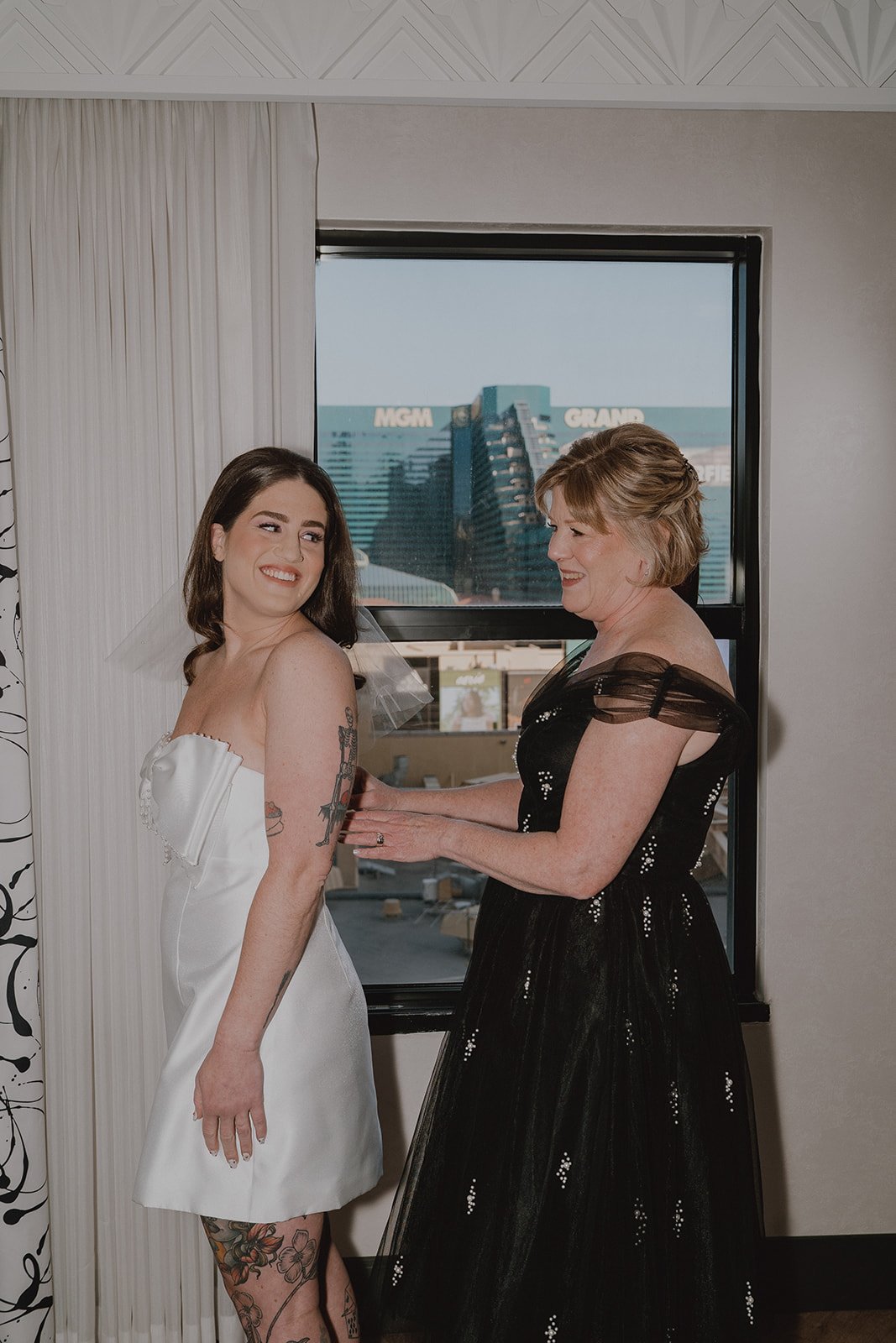 Brides mother zipping up her dress.