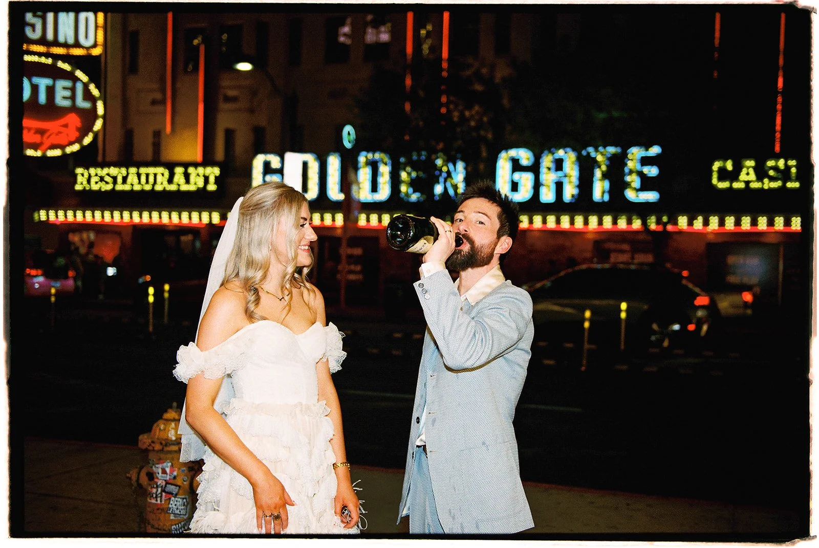 Groom drinking champagne straight from the bottle on 35mm film.
