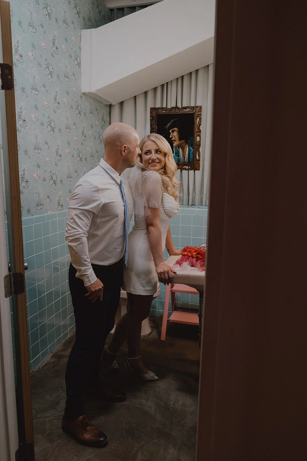 Bride and groom posing in the bathroom at Sure Thing Chapel for their Las Vegas wedding portraits.