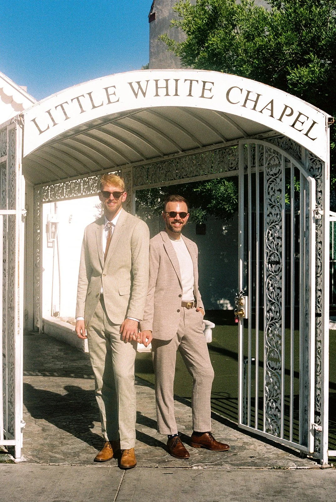 Couple posing outside of The Little White Wedding Chapel for their 35mm film elopement photos in Las Vegas.