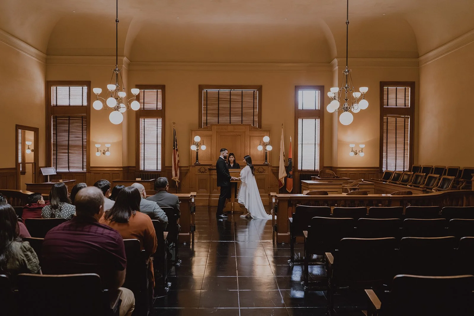 Couple holding hands during their Old Orange County Courthouse wedding ceremony.