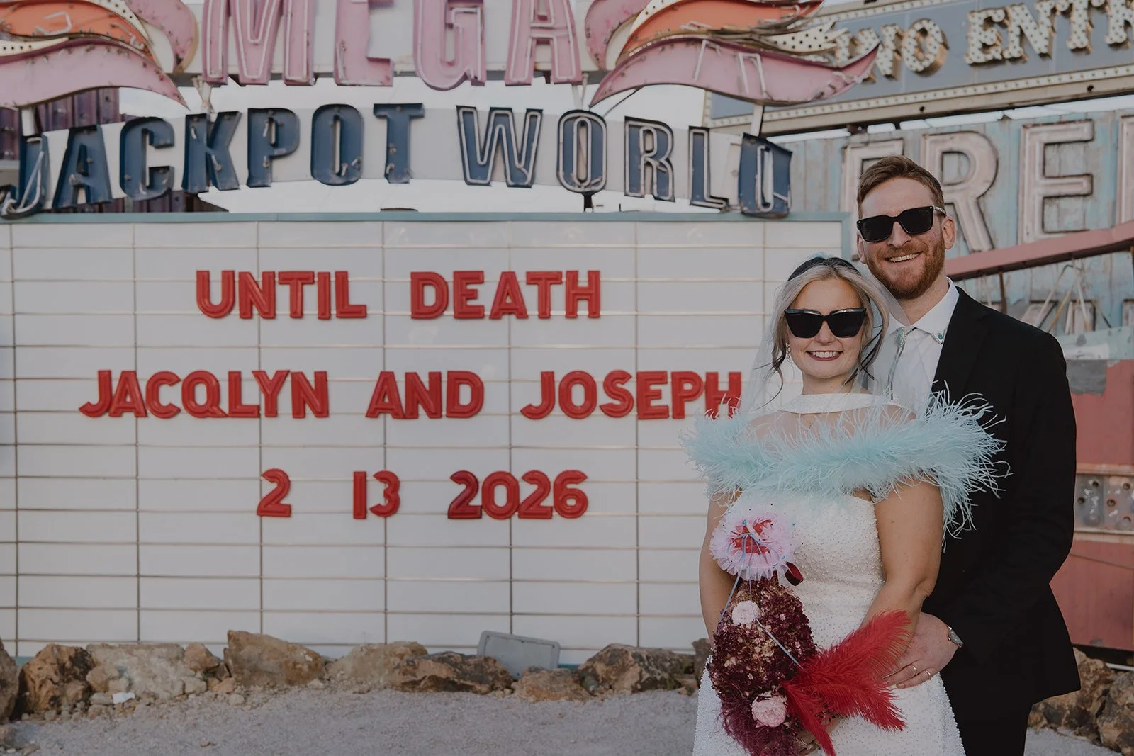 Bride and groom posing in front of their custom marquee sign for their Neon Museum Las Vegas wedding.