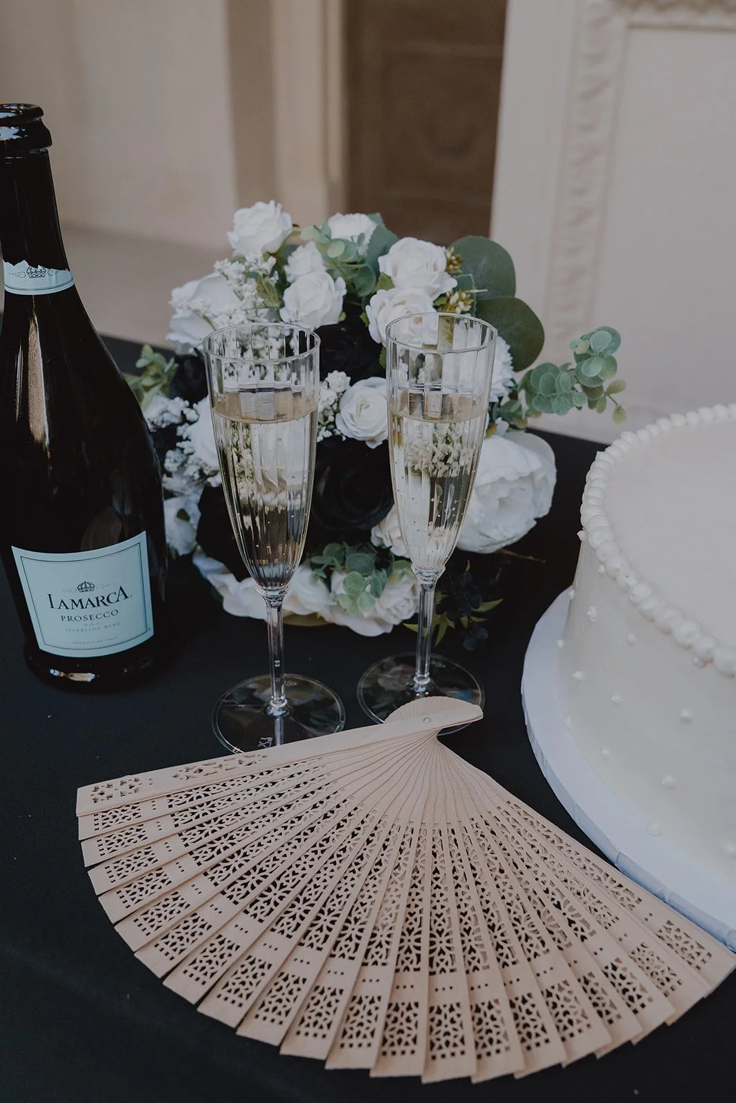 Champagne bottle, flutes, wedding bouquet, and cake table setup during a micro wedding in Las Vegas at Caesars Palace.