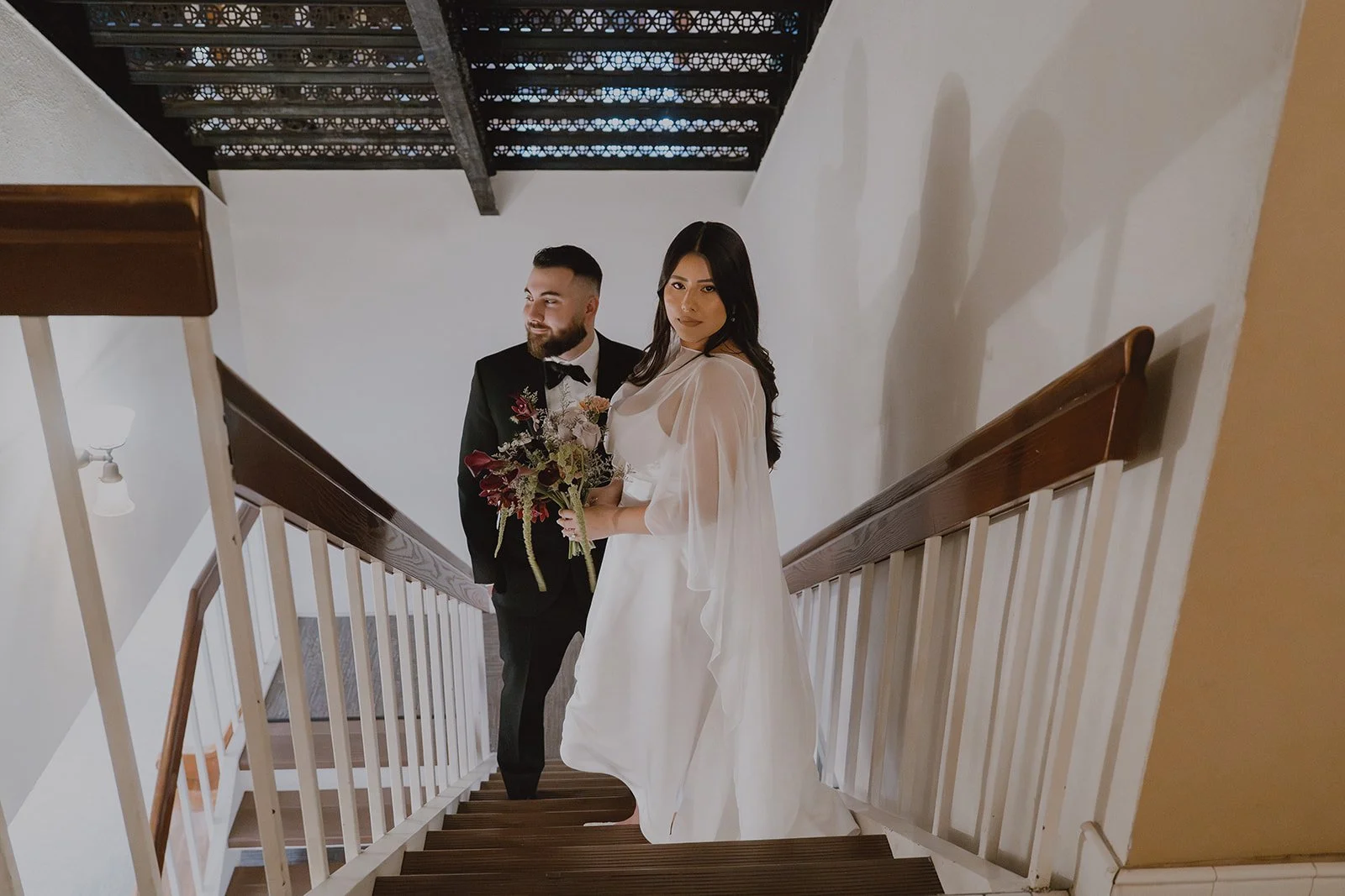 Couple posing on the staircase for their Old Orange County Courthouse wedding portraits.