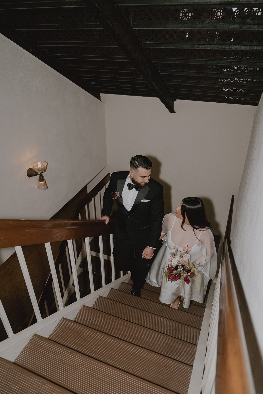Bride and groom walking up the stairs at Old Orange County Courthouse.